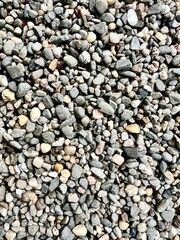 Close-up of small gray pebbles, showcasing texture. Perfect for backgrounds, nature themes, or designs highlighting natural patterns, stones, and organic elements.