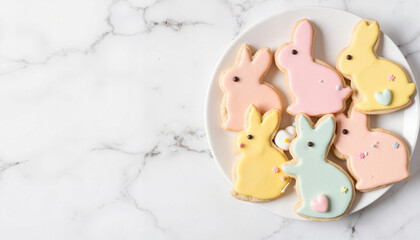 Pastel bunny-shaped Easter cookies on white marble plate