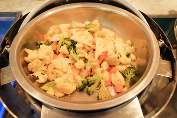 Stir-fried mixed vegetables (Capcay) served in a stainless steel container, showcasing a colorful and healthy Asian dish