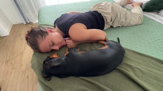 Mulher dorme com cachorro em cama 