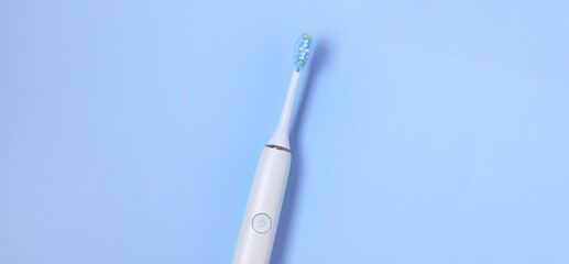 Electric toothbrush on a light blue background highlighting modern dental care and oral hygiene routine