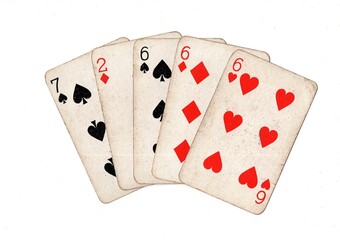 A poker hand of vintage playing cards on a white background.