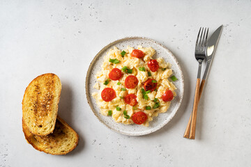 Scrambled eggs with onion and tomatoes on plate