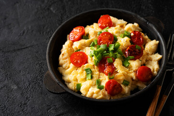 Scrambled eggs with onion and tomatoes on plate