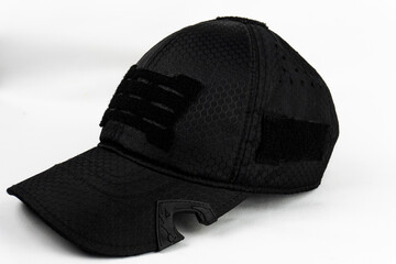 Angled view of a black tactical cap with a bottle opener feature, set against a clean white background.