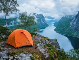 Red tent pitched near cliff edge overlooking fjord in Norway