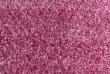Close up of pink homemade knitted fabric with large stitches. Textured background