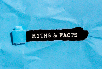 Myths and facts message written on ripped blue torn paper on black background. Conceptual myths and...