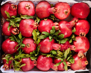A box of pomegranate fruits.