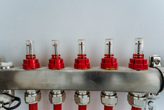 This image features a detailed close up of a stainless steel pipe that has bright red caps securely fitted on both ends, showcasing its industrial design and functionality