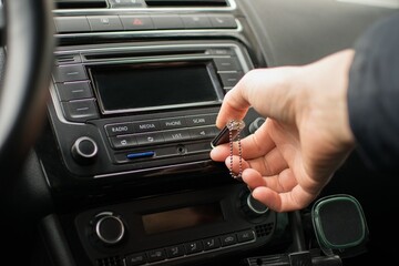 The driver's hand inserting a USB flash drive into the car's radio
