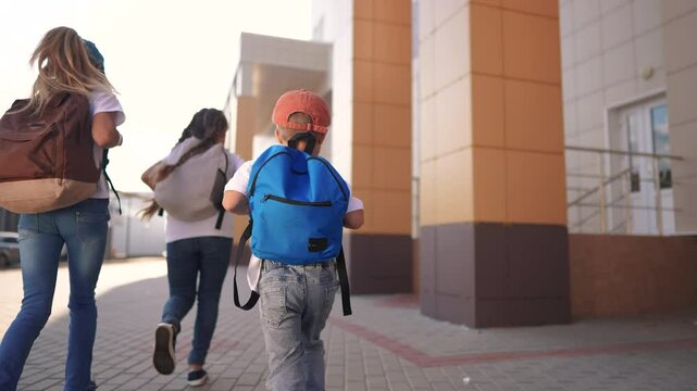 A group of girls running back to school. Bag elementary happy concept. Children running around in a backpack at school. A group of children lifestyle running back to school with their backpacks.