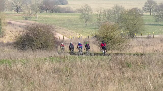 a peleton of UK sports cyclists riding through countryside