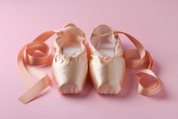 Pair of beautiful pointe shoes on pink background