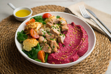 Complete dish with pork, beetroot cream and roasted cauliflower.