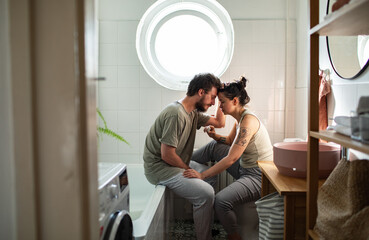 Couple reacting to positive pregnancy test in bathroom