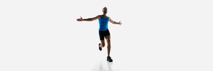 Champion. Athletic, determined man, runner winning marathon isolated on white studio background. Concept of sport, competition, endurance, athletics, sportive lifestyle. Copy space