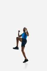 Fototapeta premium Emotional man, professional runner celebrating victory, jumping in happiness isolated on white studio background. Concept of sport, competition, endurance, athletics, sportive lifestyle. Copy space