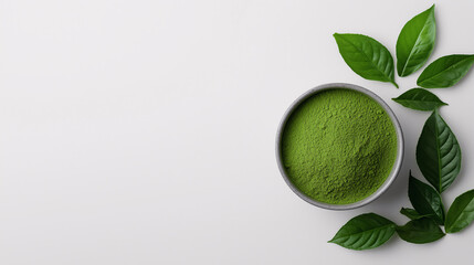 small bowl of vibrant green powdered matcha tea alongside fresh kratom leaves, all placed on a smooth white background