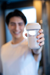 ジムでプロテインを持つ日本人男性