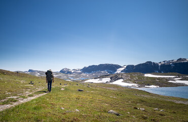 Man with a backpack hiking in a nordic moutain area
