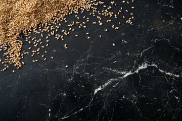 Obraz premium Golden wheat grains scattered on black marble surface with texture