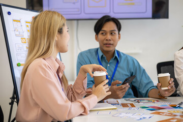 A group of people are sitting around a table, talking and drinking coffee. Scene is friendly and social, as the people are engaged in conversation and enjoying each other's company

