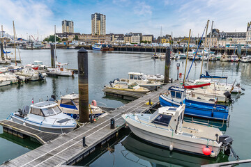 Fototapeta premium A view past moored boats across the middle inner harbor at Cherbourg, France in autumn