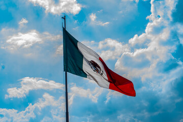 Bandera de México ondeando en el cielo cubierto de nubes a la luz del día 