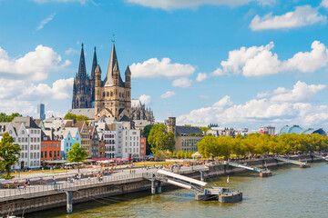 view of Cologne Cathedral and the Hohenzollern Bridge. The Gothic architecture of the cathedral...
