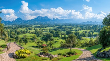 Naklejka premium Panoramic view of a golf course nestled in a lush green valley, mountains in the background