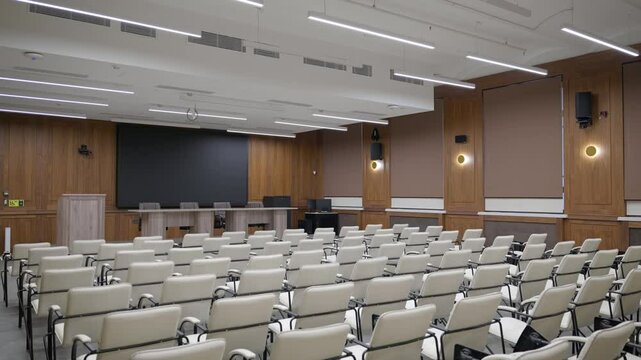 Modern empty classroom, lecture hall, with white chairs and brown wooden walls