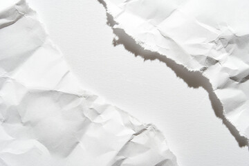 Close-up of torn white paper with rough edges and textured surface creating abstract composition.