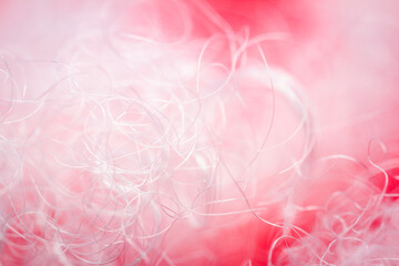Extreme macro of polyester stable fiber on red background. Selective focus, shallow depth of field. Abstract dreamy background