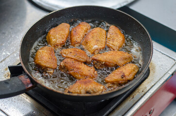Frying chicken wings in a pan