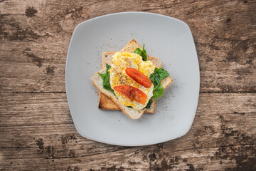 Breakfast sandwich with egg, watercress and tomato on the wooden table, healthy food