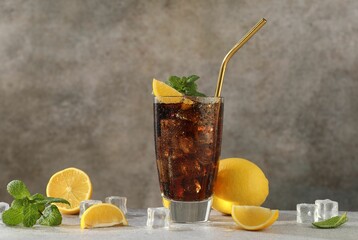 Fresh iced cola with mint and lemons on grey table