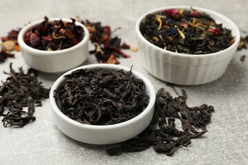 Different types of tea brew on grey table, closeup