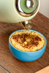 Pouring boiling water over instant noodles with spices.