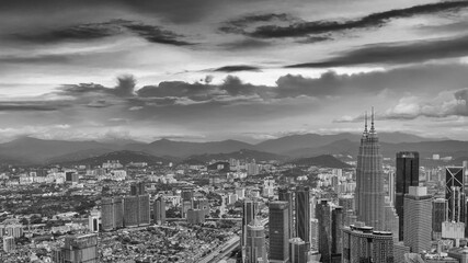 Dramatic aerial view of Kuala Lumpur skyline on a cloudy day with misty skyscrapers
