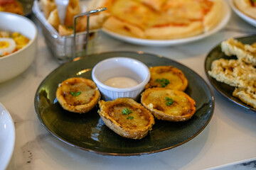 baked pane pasta with mayonnaise sauce served on a black plate