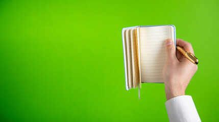 Man holding notepad with a pen.