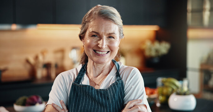 Portrait, mature woman and chef at house with confidence, cooking skills and hospitality services. Smile, female person and arms crossed for culinary ambition, catering industry and personalized menu