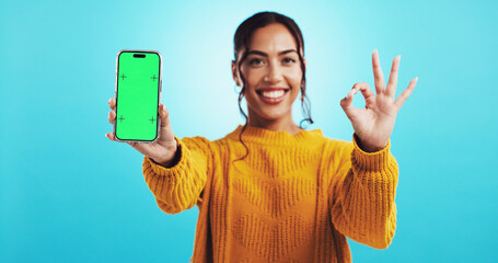 OK hand, woman and phone with green screen for deal, information and choice on blue background. Student, portrait and approval gesture with mockup, space and sign up promotion of university website