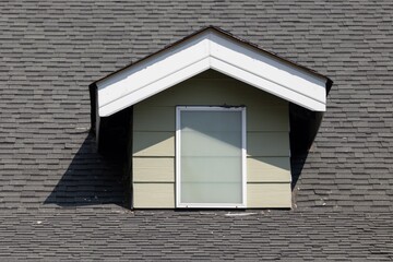A window with a white frame sits on a roof © Rattanachat