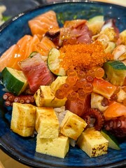 Closeup japanese rice bowl with seafood and omelette