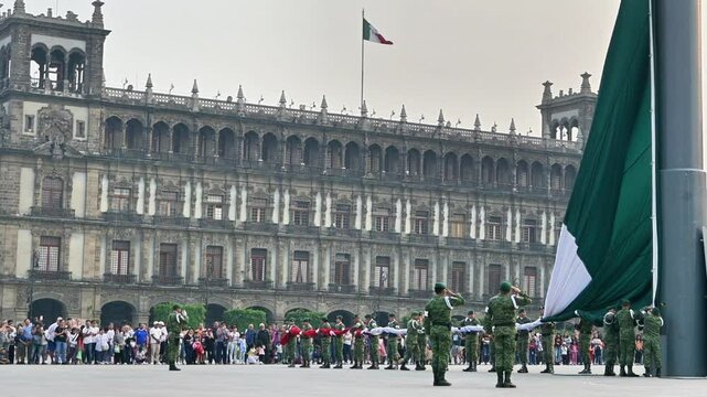 A group of soldiers stand in front of a large building with a green flag. The flag is being raised and the soldiers are saluting. The scene is patriotic and shows respect for the country