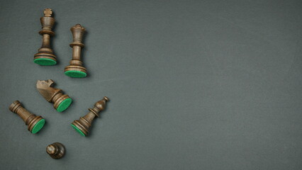 Brown wooden chess pieces on the left on a gray background. Space for text
