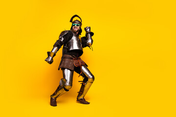 Medieval knight in full armor posing humorously against bright yellow background, blending ancient history with modern fun.