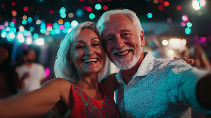 Cheerful elderly couple taking selfie at night party, enjoying holidays and having fun together